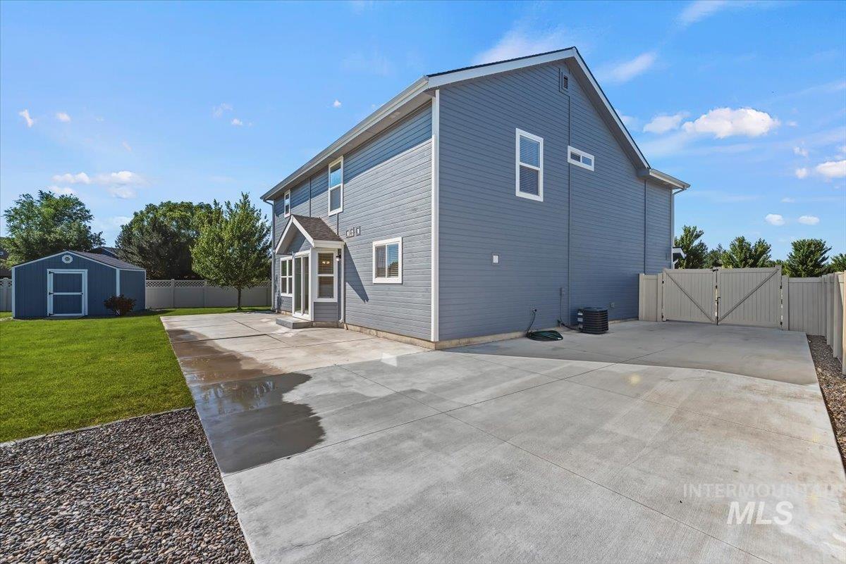 12310 West Hidden Point Drive Star, ID 83669 - Photo 39 of 48 Expansive concrete patio alongside a two-story residence with gray siding and white trim