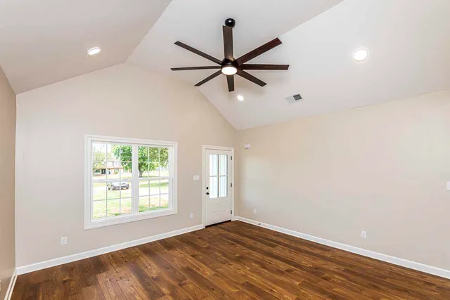 an empty room with fan and windows