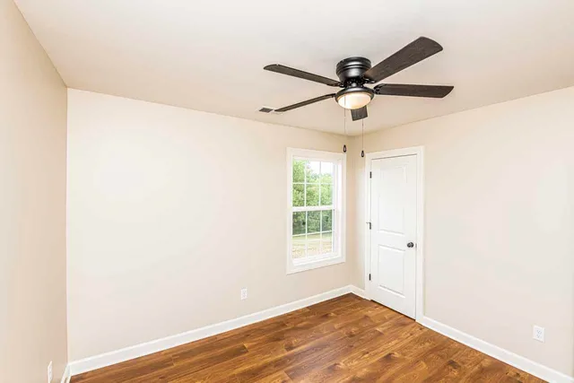 a view of a room with a ceiling fan and a window