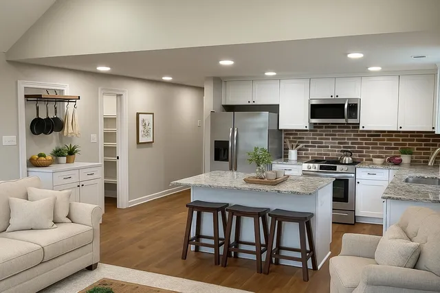 a kitchen with stainless steel appliances kitchen island granite countertop a stove a sink a dining table and chairs