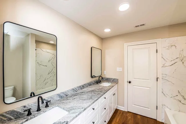 a bathroom with a granite countertop sink and a mirror