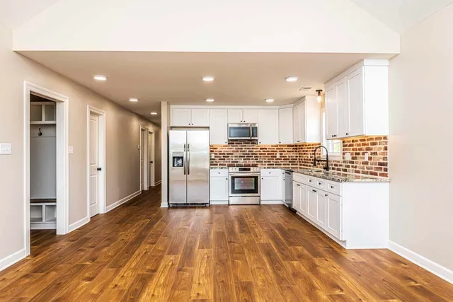 a large kitchen with kitchen island a sink stainless steel appliances and cabinets