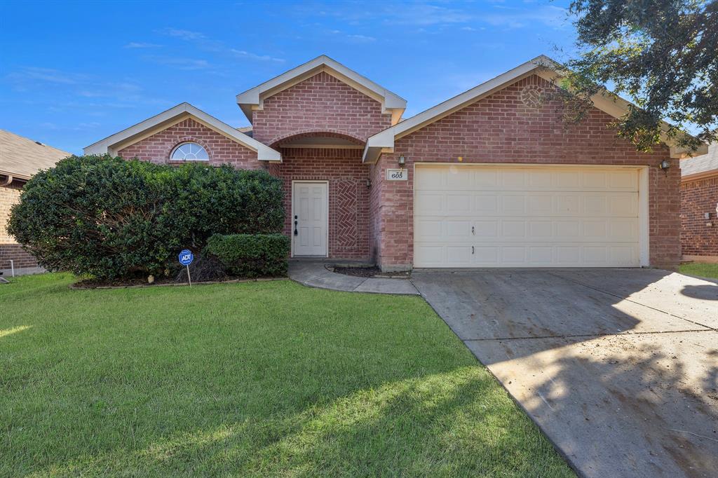 605 Clearbrook Street Azle, TX 76020 - Photo 32 of 33 Brick facade home featuring a two-car garage, arched entry, manicured shrubbery, and a front lawn