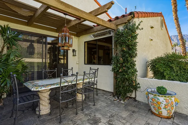 a view of a patio with table and chairs potted plants