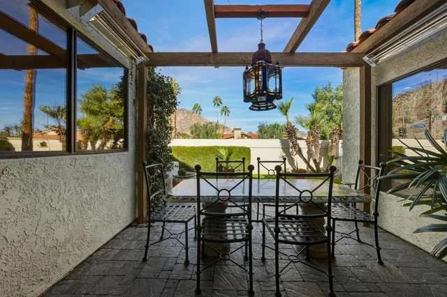 a view of a patio with table and chairs and potted plants