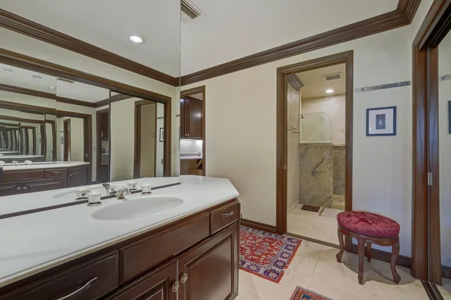 a bathroom with a sink a toilet a mirror and shower