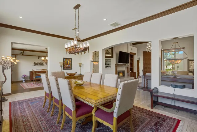 a dining room with furniture a chandelier and wooden floor