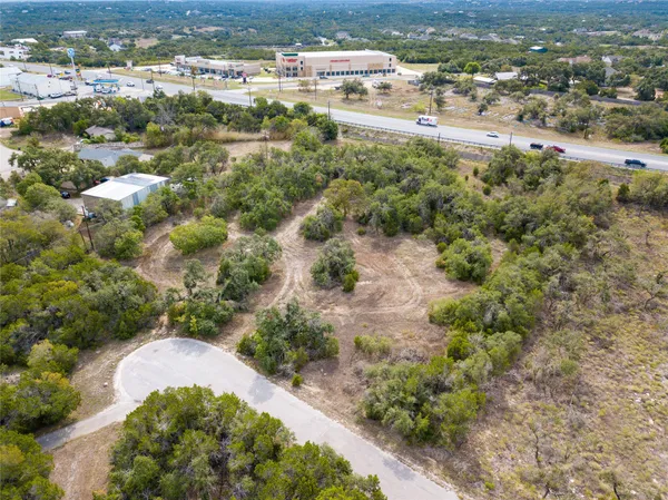 an aerial view of residential houses with outdoor space and trees