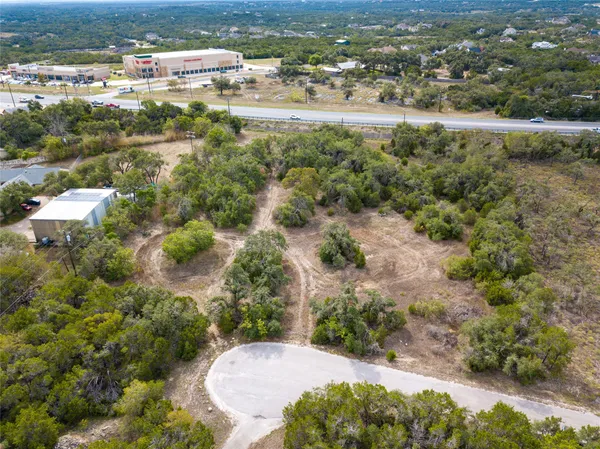 an aerial view of residential houses with outdoor space and trees