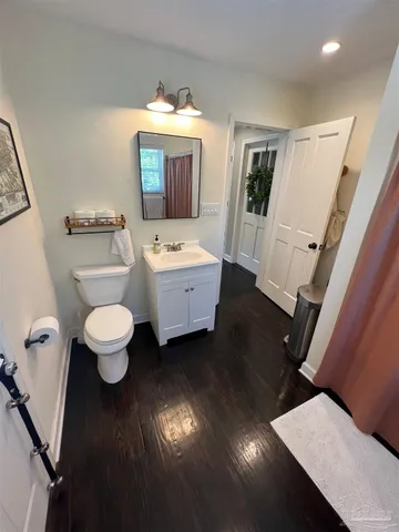 a bathroom with a toilet sink a mirror and vanity
