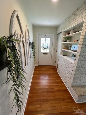 a view of a hallway with wooden floor and staircase