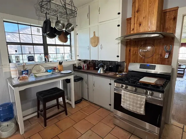 a kitchen with a stove a sink and cabinets