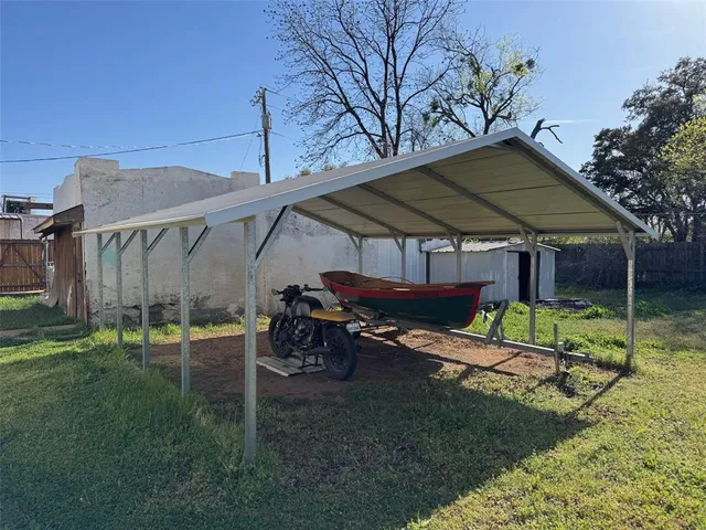 a view of backyard with table and chairs under an umbrella