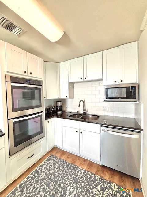 604 Maple Street Port O'Connor, TX 77982 - Photo 14 of 46 a kitchen with stainless steel appliances granite countertop a sink a stove a microwave and cabinets