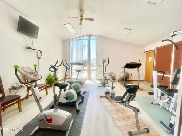 a living room with furniture gym equipment and a large window