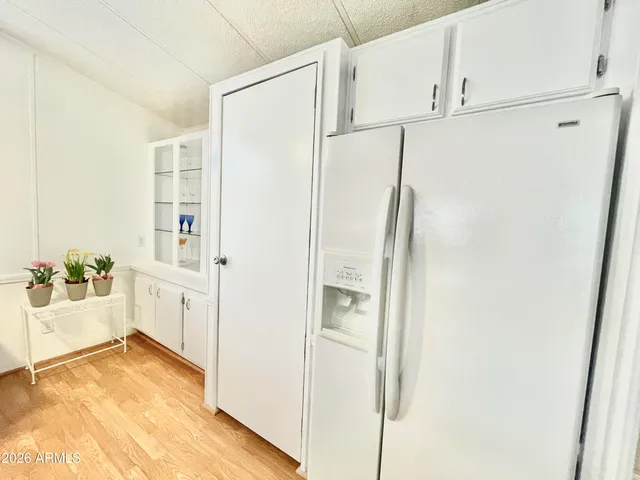 a view of a kitchen with a refrigerator and white cabinets