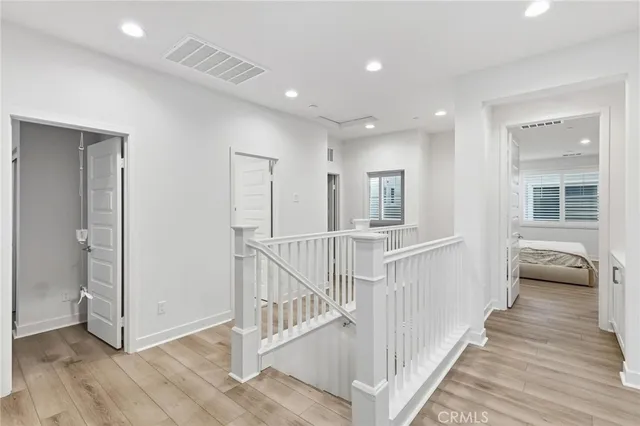 a view of a hallway with wooden floor and windows
