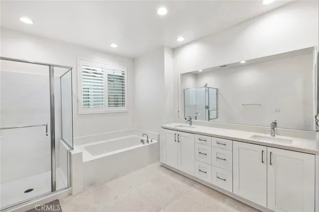 a spacious bathroom with a double vanity sink a mirror and a bathtub