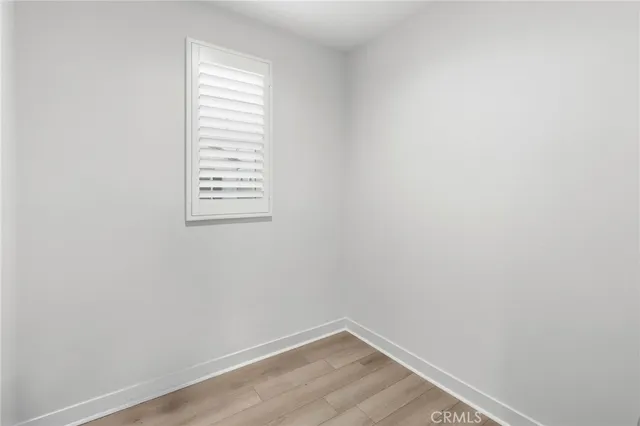 a view of a small space with wooden floor and a window