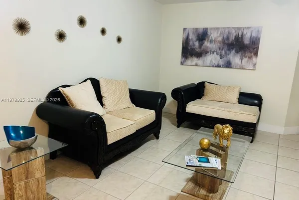 a living room with furniture and a painting on the wall