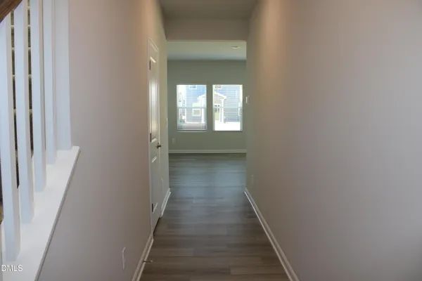 a view of a hallway with wooden floor and a window