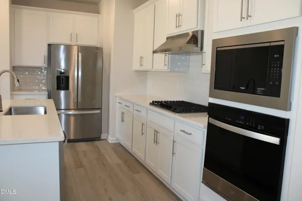 a kitchen with stainless steel appliances a refrigerator stove and microwave