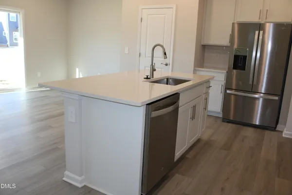a kitchen with a refrigerator sink and cabinets