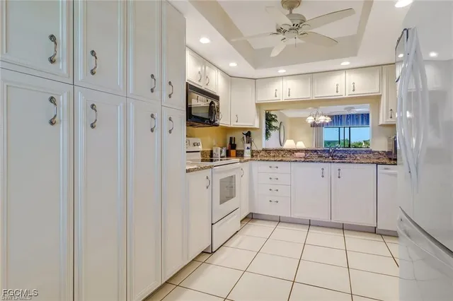 a kitchen with white cabinets and white appliances