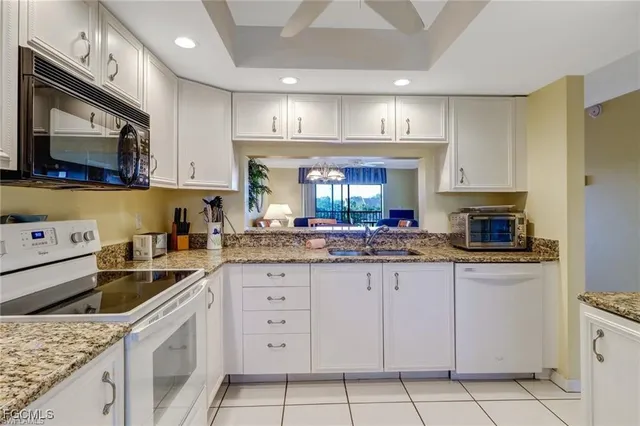 a kitchen with granite countertop a sink stainless steel appliances and cabinets