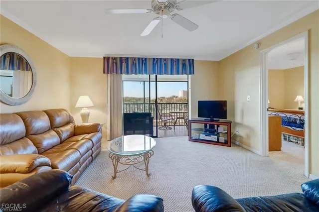 a living room with furniture a flat screen tv and a large window