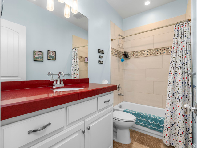 968 South Cyn Road Santaquin, UT 84655 - Photo 24 of 36 Bathroom featuring a red countertop with integrated sink, white vanity cabinetry, and a shower-over-tub combination with light-toned rectangular wall tiles and a decorative mosaic accent band