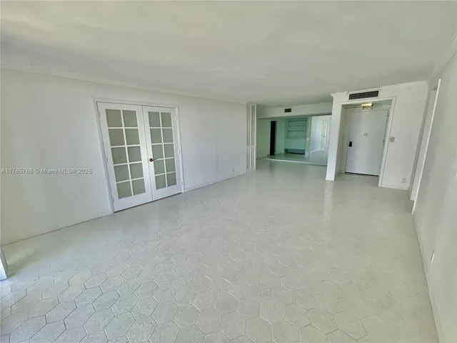 an empty room with a window and a kitchen