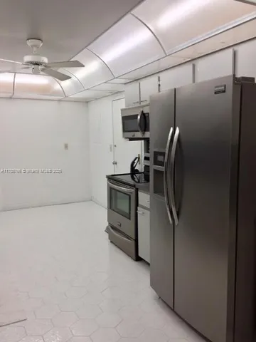 a view of a refrigerator in kitchen and a window