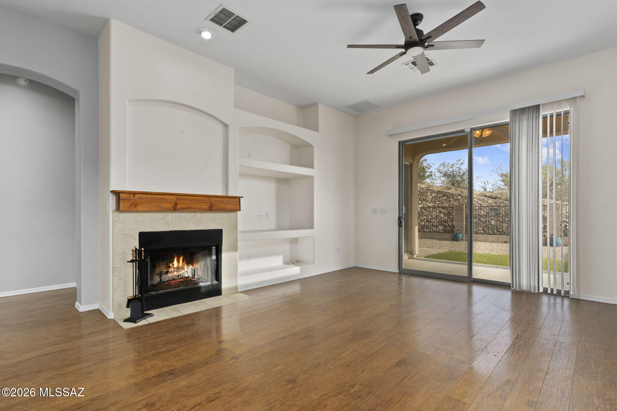 13668 East High Plains Ranch Street Vail, AZ 85641 - Photo 16 of 51 a view of an empty room with wooden floor fireplace and a window