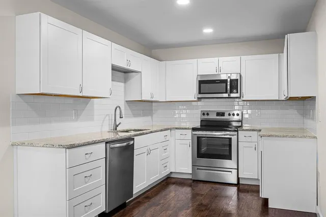 a kitchen with appliances a sink and cabinets