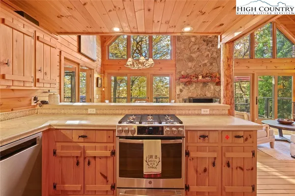 a kitchen with stainless steel appliances granite countertop a refrigerator a sink dishwasher a stove and white countertops with wooden floor