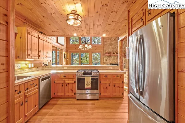 a kitchen with stainless steel appliances granite countertop a refrigerator and wooden floor