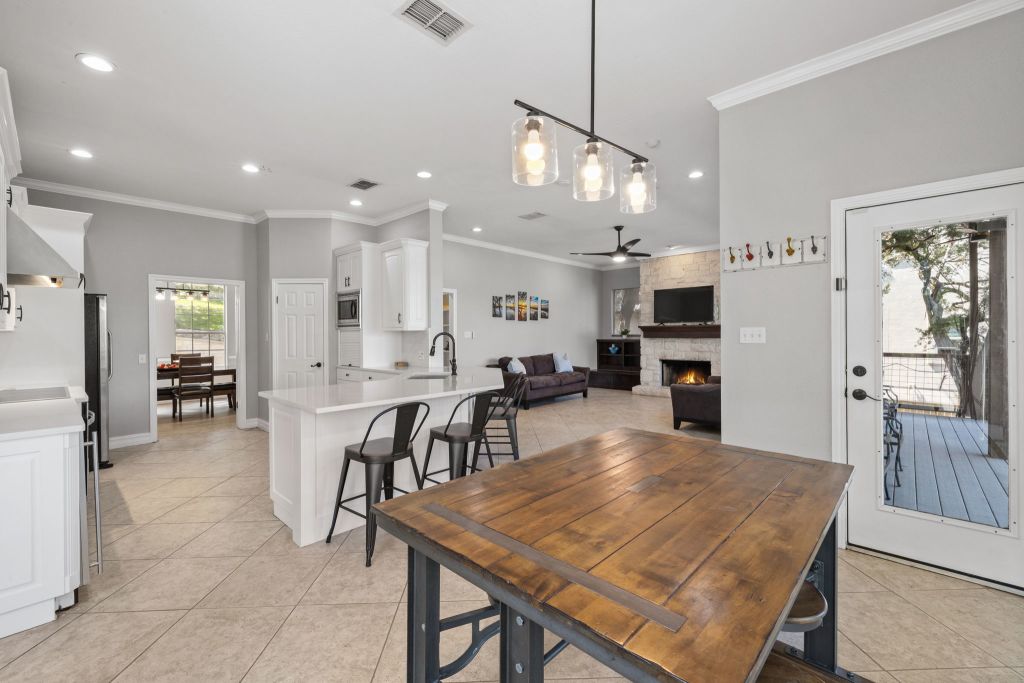 10800 Beach Road Leander, TX 78641 - Photo 8 of 39 An open concept design seamlessly connects a bright kitchen to a cozy living area, creating an inviting gathering space.
