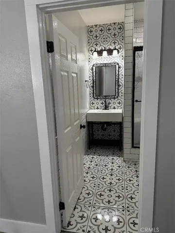 a bathroom with a glass door shower and a sink
