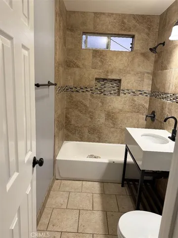 a bathroom with a sink a toilet and bathtub