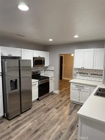 a kitchen with granite countertop stainless steel appliances and wooden cabinets