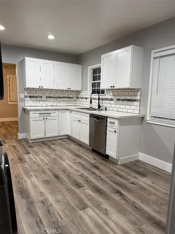 a kitchen with granite countertop white cabinets and white appliances