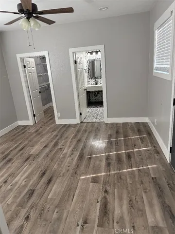 a view of empty room with wooden floor and window
