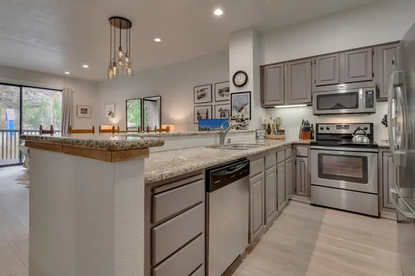 a kitchen with stainless steel appliances granite countertop a sink and stove top oven