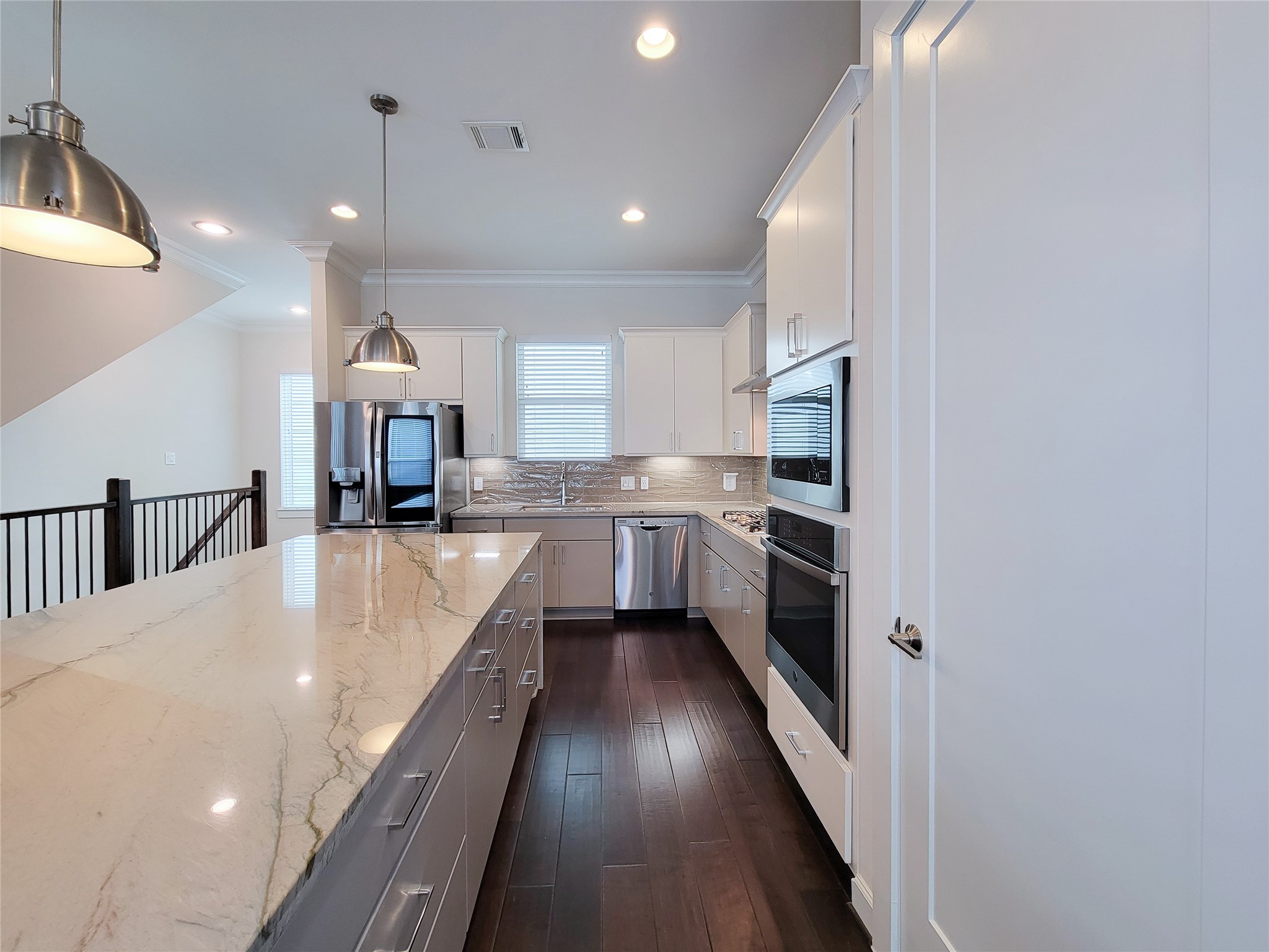 845 Fisher Street, Unit E Houston, TX 77018 - Photo 18 of 47 a large kitchen with kitchen island a large counter space a sink stainless steel appliances and cabinets