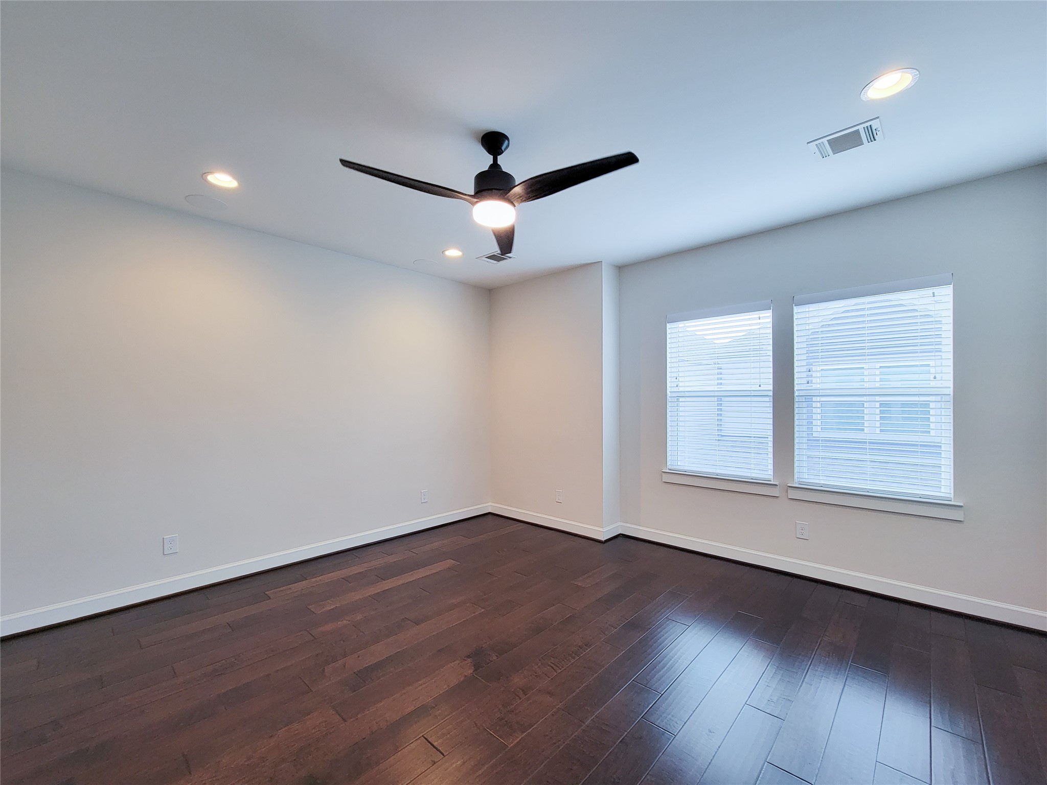 845 Fisher Street, Unit E Houston, TX 77018 - Photo 36 of 47 an empty room with wooden floor ceiling fan and windows
