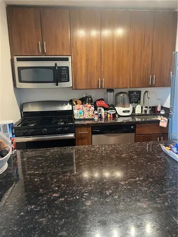 a kitchen with sink refrigerator and chairs