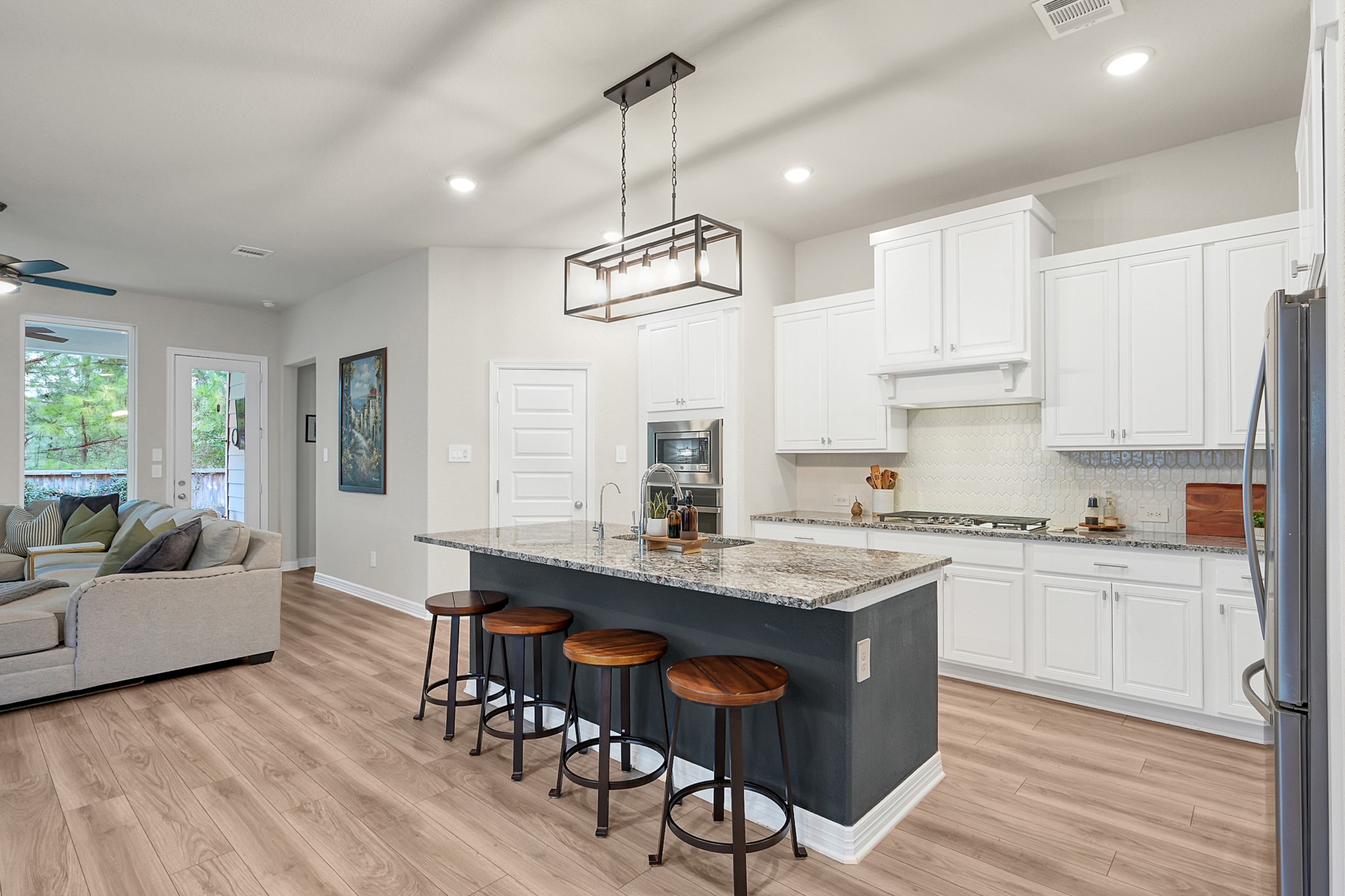 105 Dove Springs Court Conroe, TX 77304 - Photo 14 of 49 a kitchen with kitchen island granite countertop a table chairs sink and cabinets