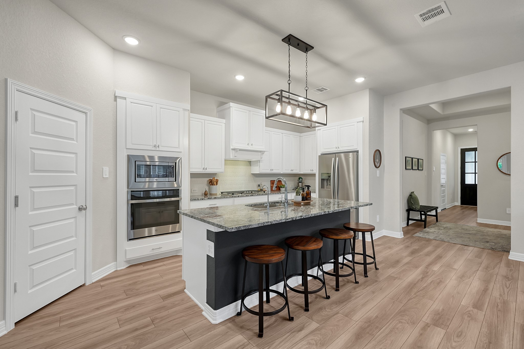 105 Dove Springs Court Conroe, TX 77304 - Photo 15 of 49 a kitchen with stainless steel appliances kitchen island granite countertop a table chairs and a refrigerator