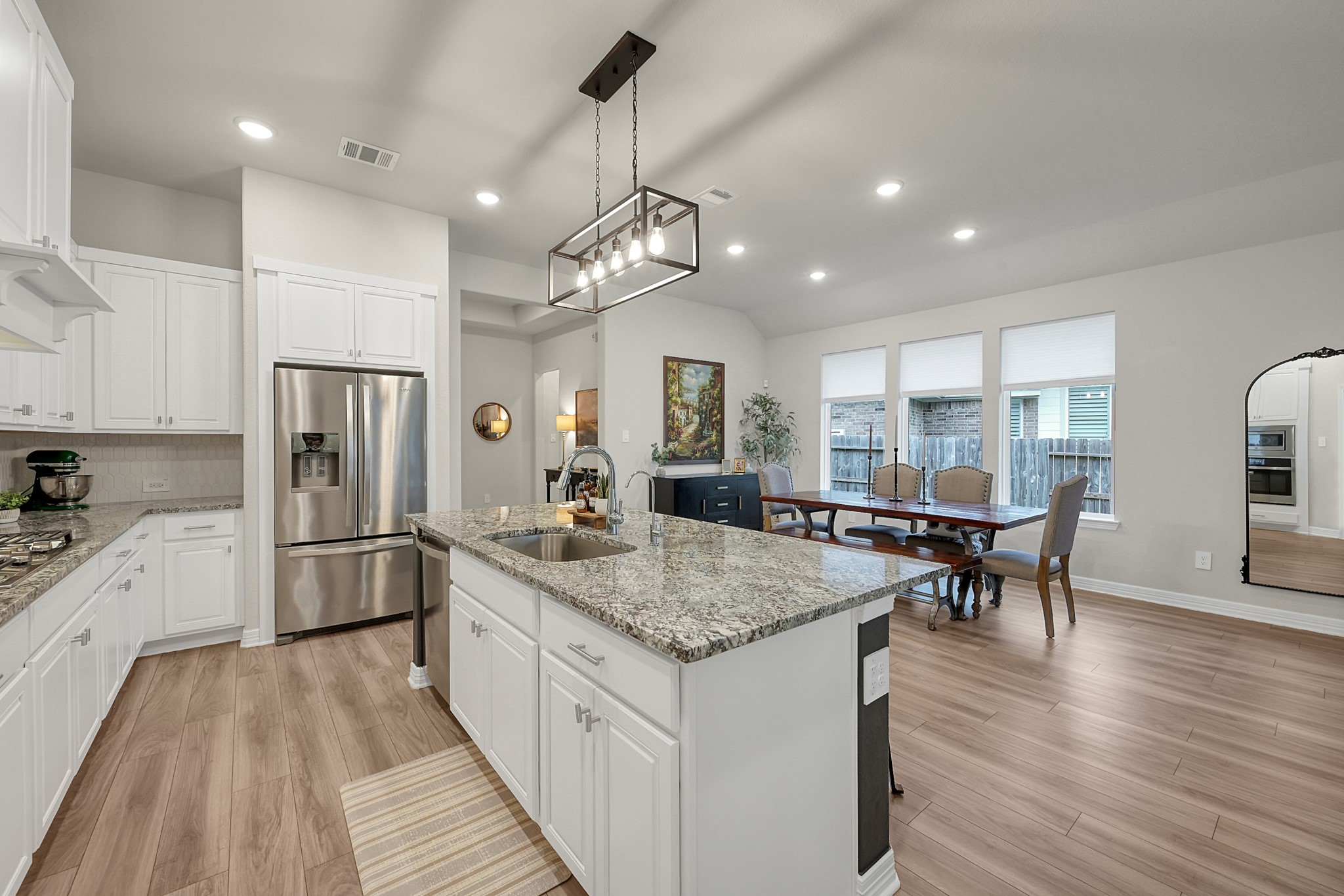 105 Dove Springs Court Conroe, TX 77304 - Photo 16 of 49 a kitchen with stainless steel appliances granite countertop hardwood floor sink stove dining table and chairs
